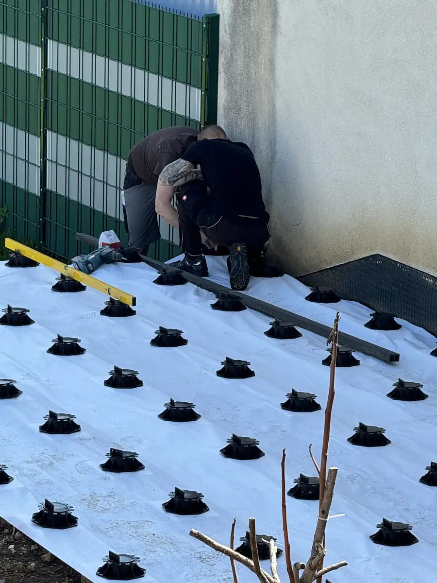 Verstellbare Unterkonstruktion mit Terrassenpads wird verlegt